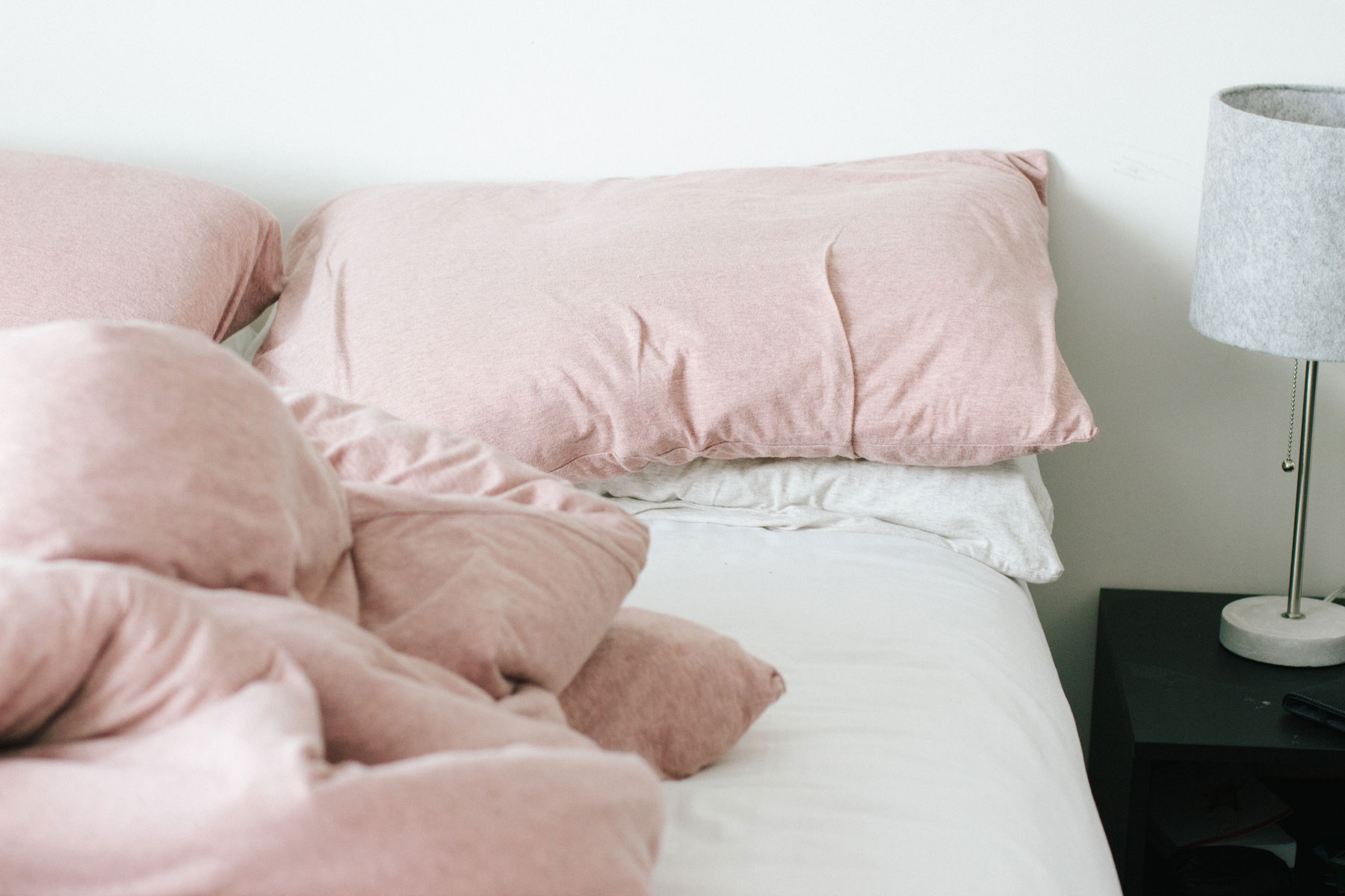 unamde bed with pink pillows