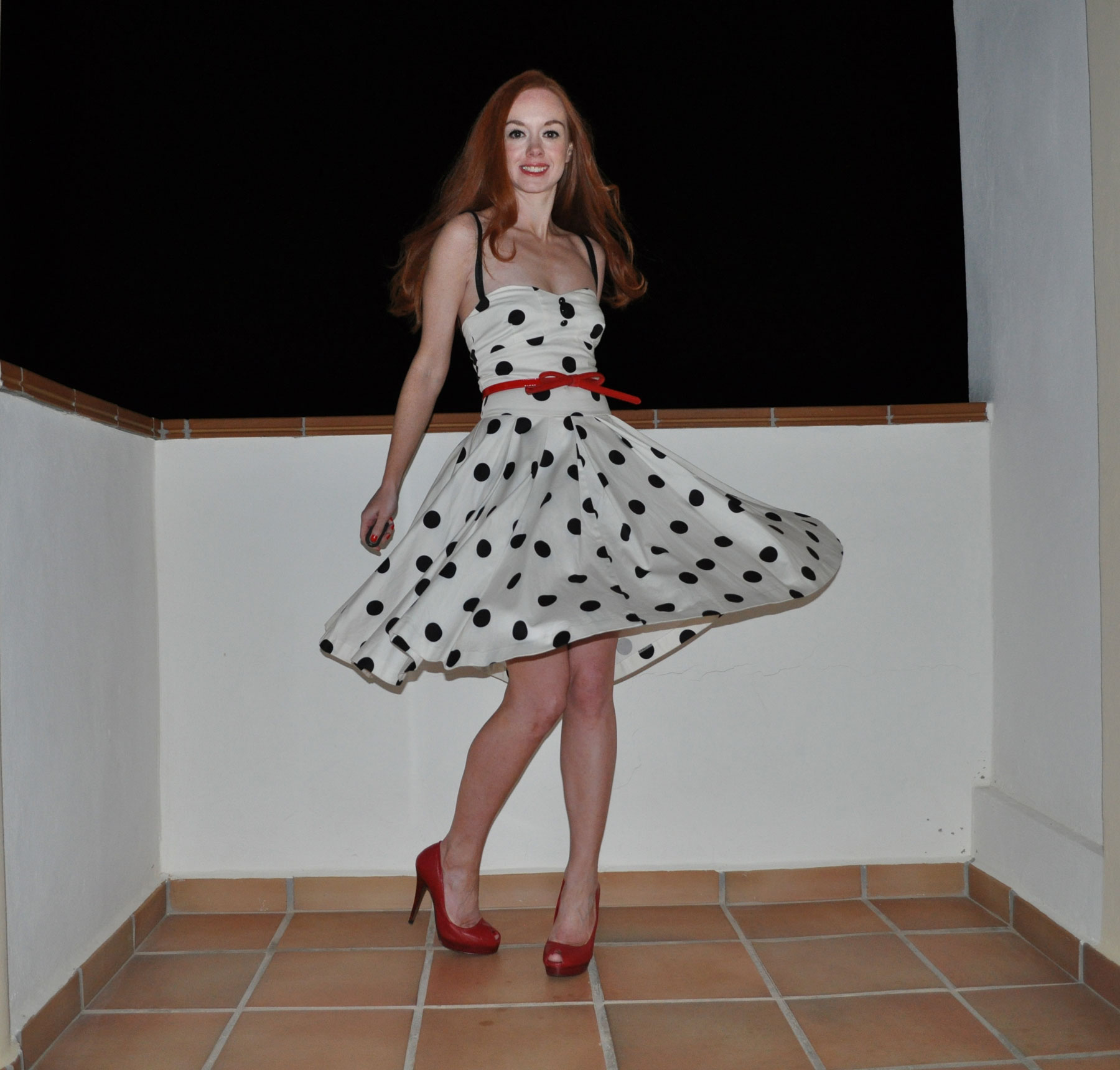 black and white polka dot dress with red high heels
