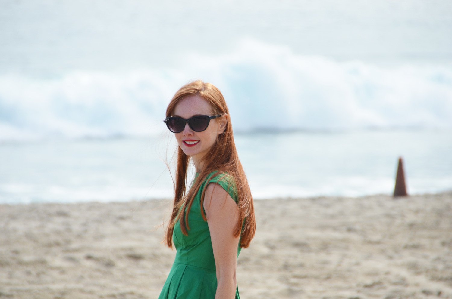 redhead in fgreen dress on the beach