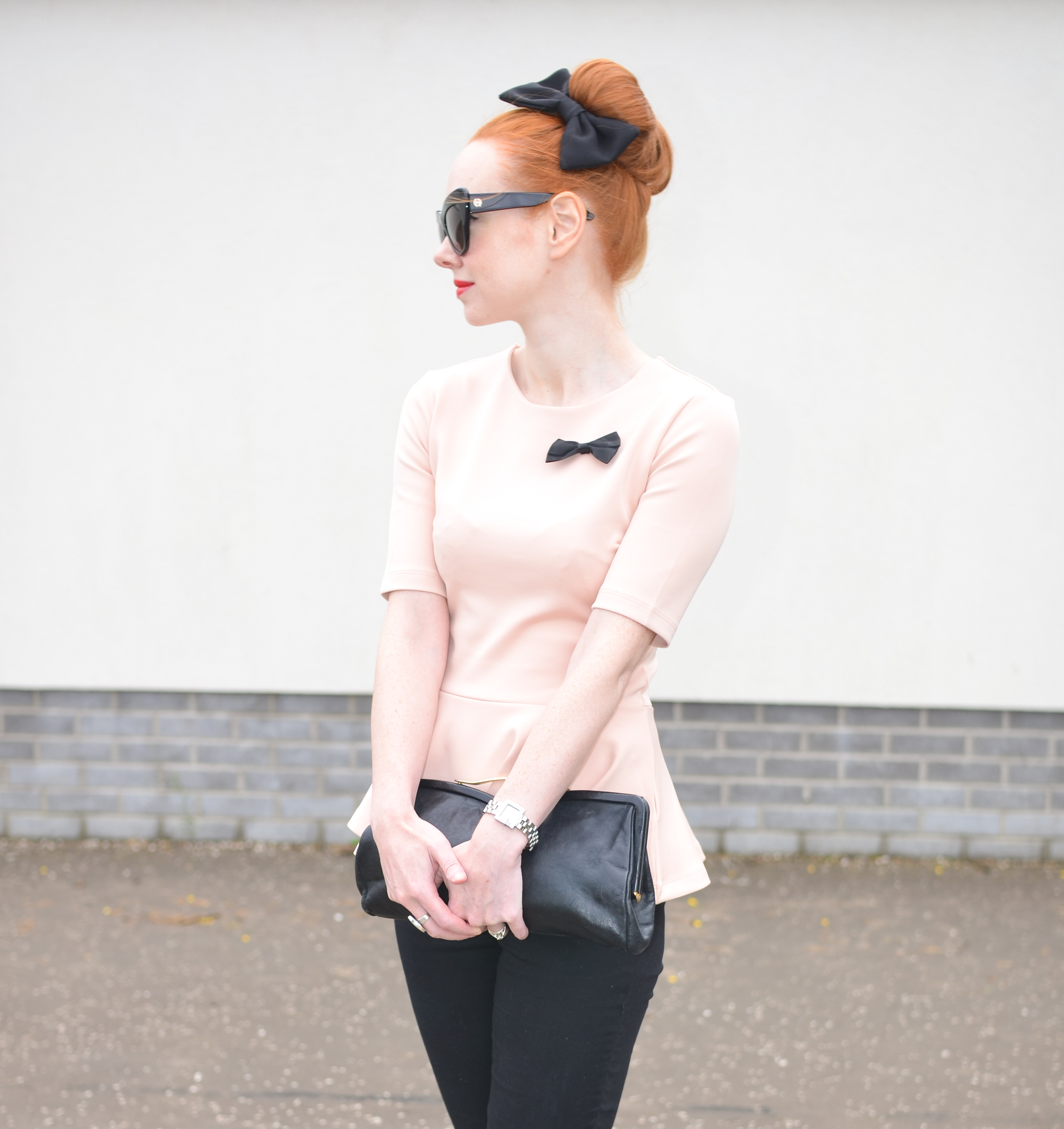 pink peplum top with black ankle pants and high heels