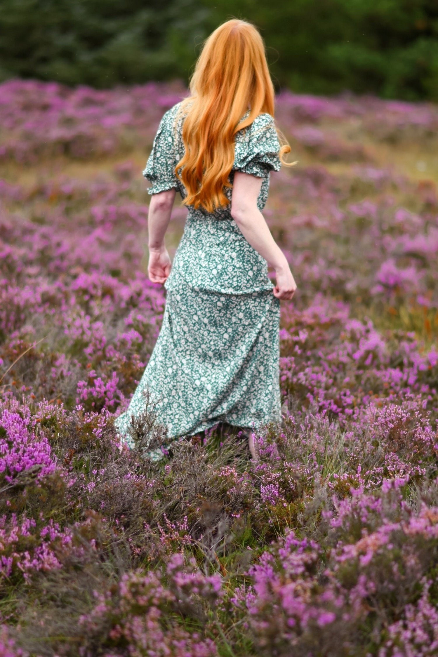 redhead wearing green floral dress in field of purple heather