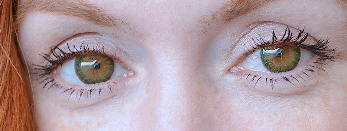 closeup of green contact lenses on brown eyes