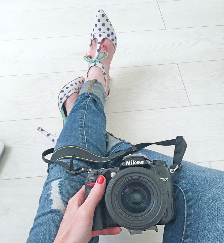 Nikon camera, ripped jeans, polka dot shoes, basic blogger pose