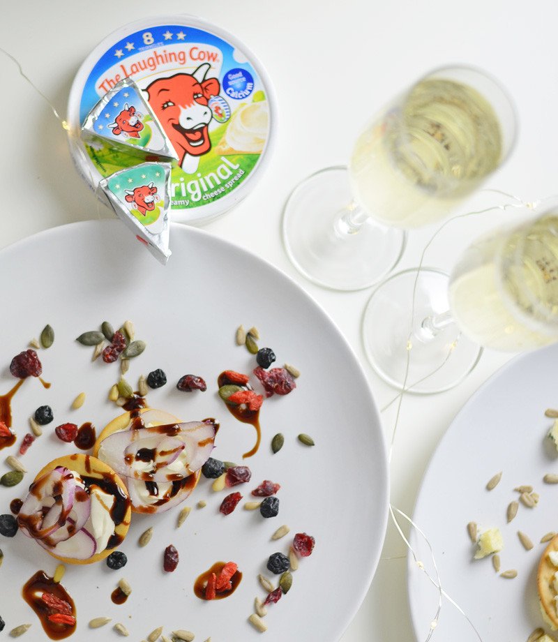 The Laughing Cow soft cheese on crackers with champagne