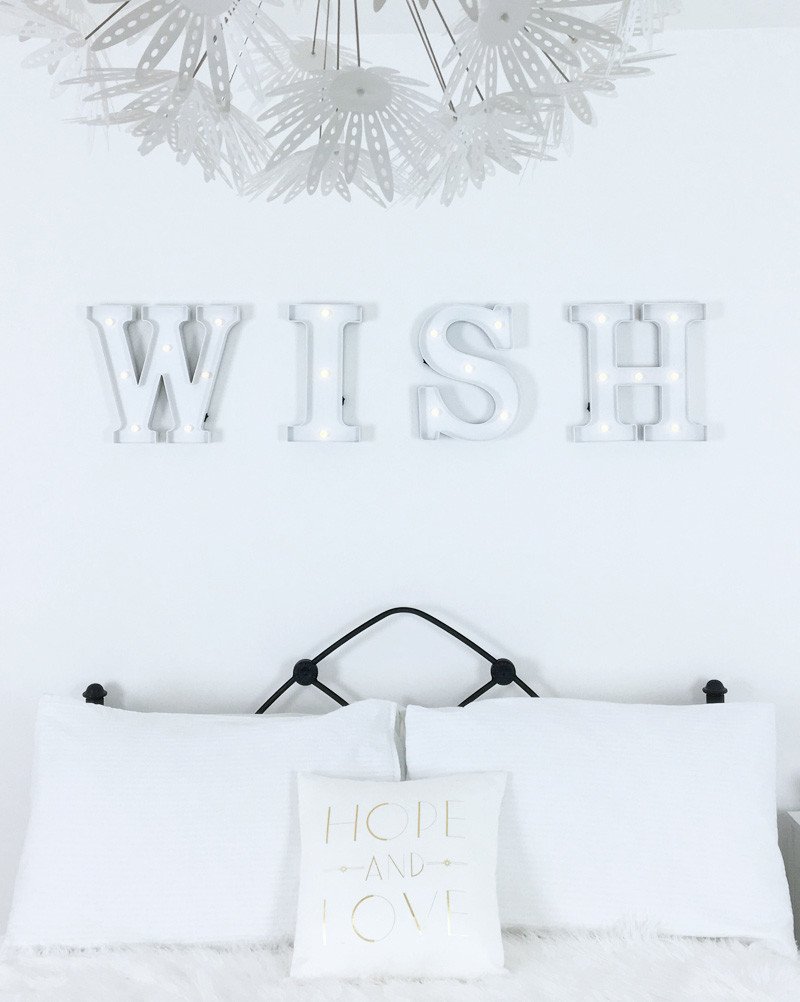 WISH Led letter lights on wall of all-white bedroom
