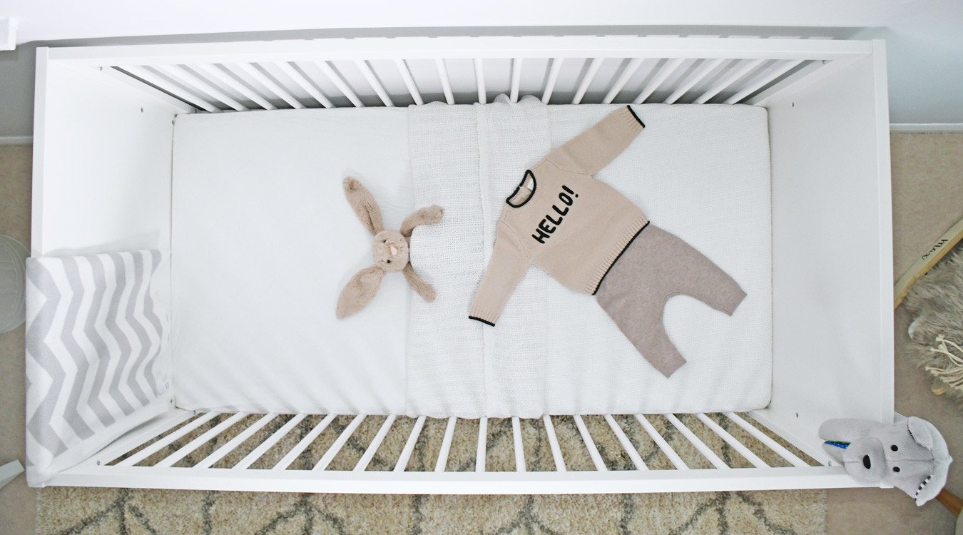 baby clothes in white cot bear
