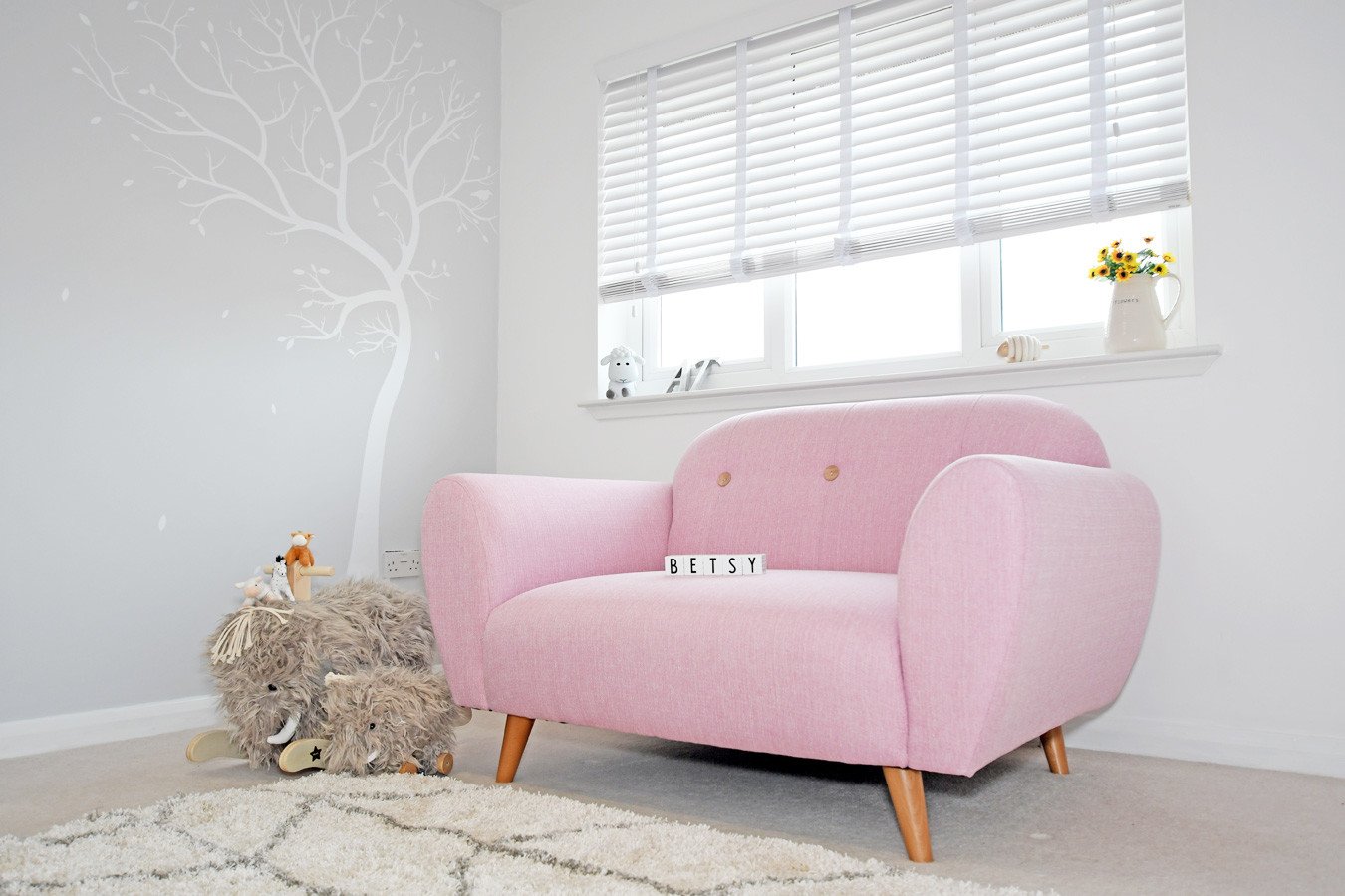 pink two-seater sofa in nursery