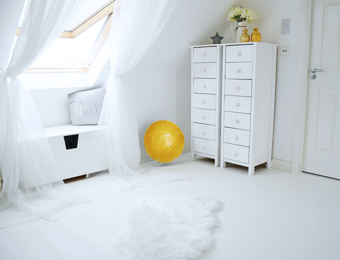 all white bedroom with white wood floor and tallboys