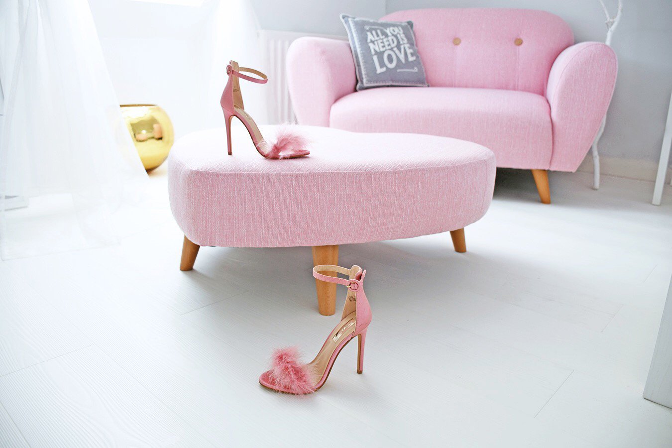 pink sofa and shoes on white wood floor