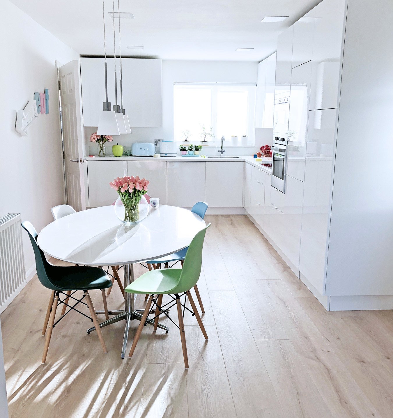 white gloss kitchen with pale wood floor
