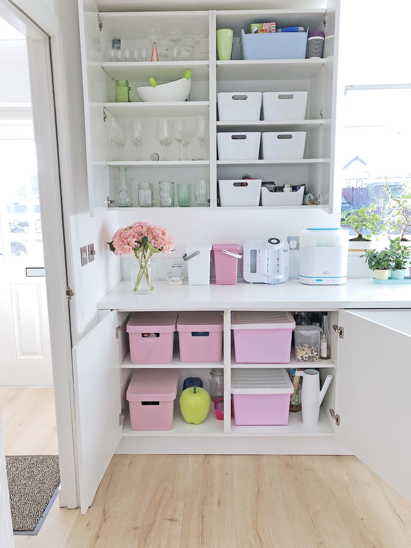 kitchen organisation: pink storage boxes in white kitchen