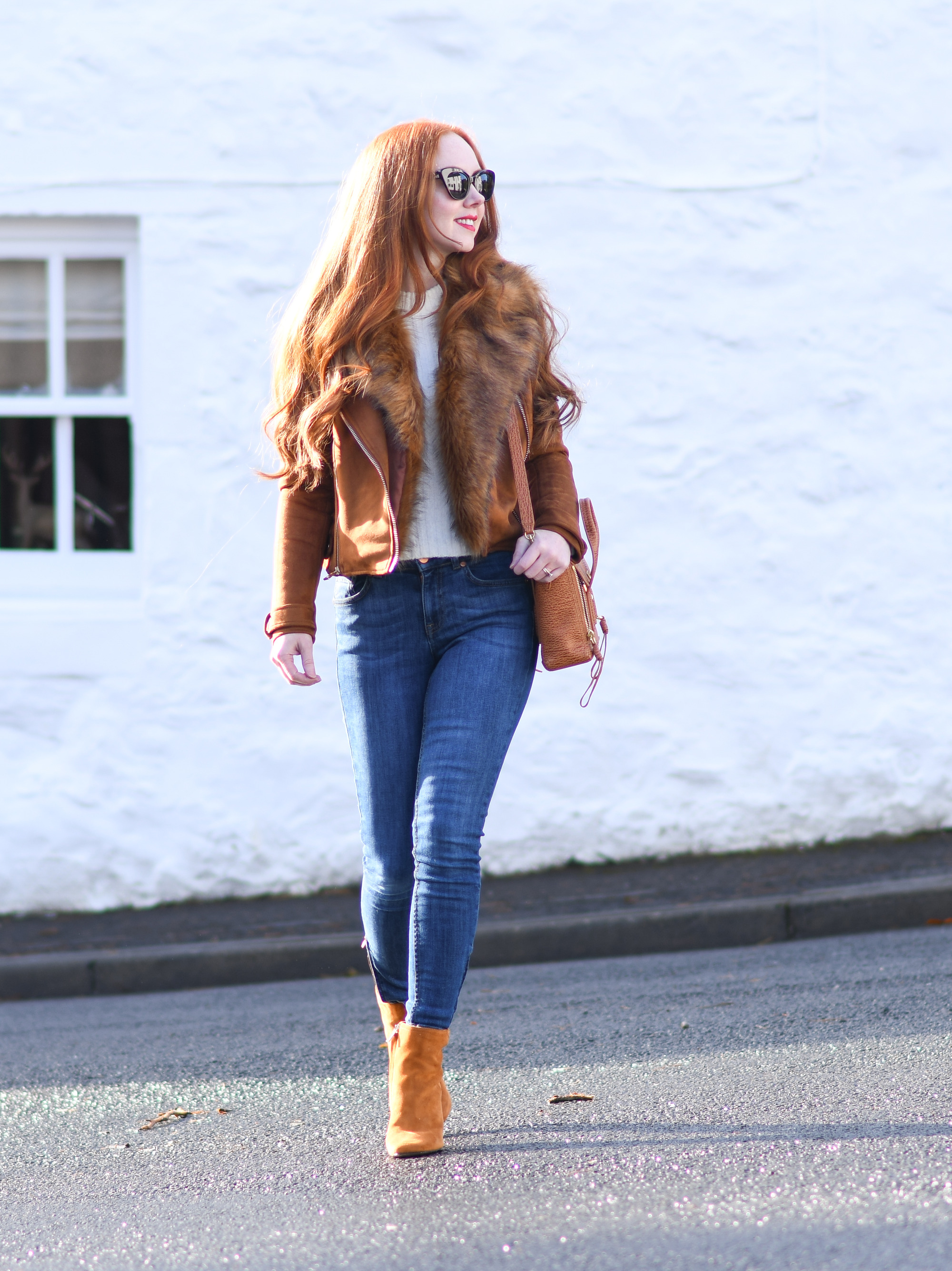 tan suede biker jacket with blue jeans