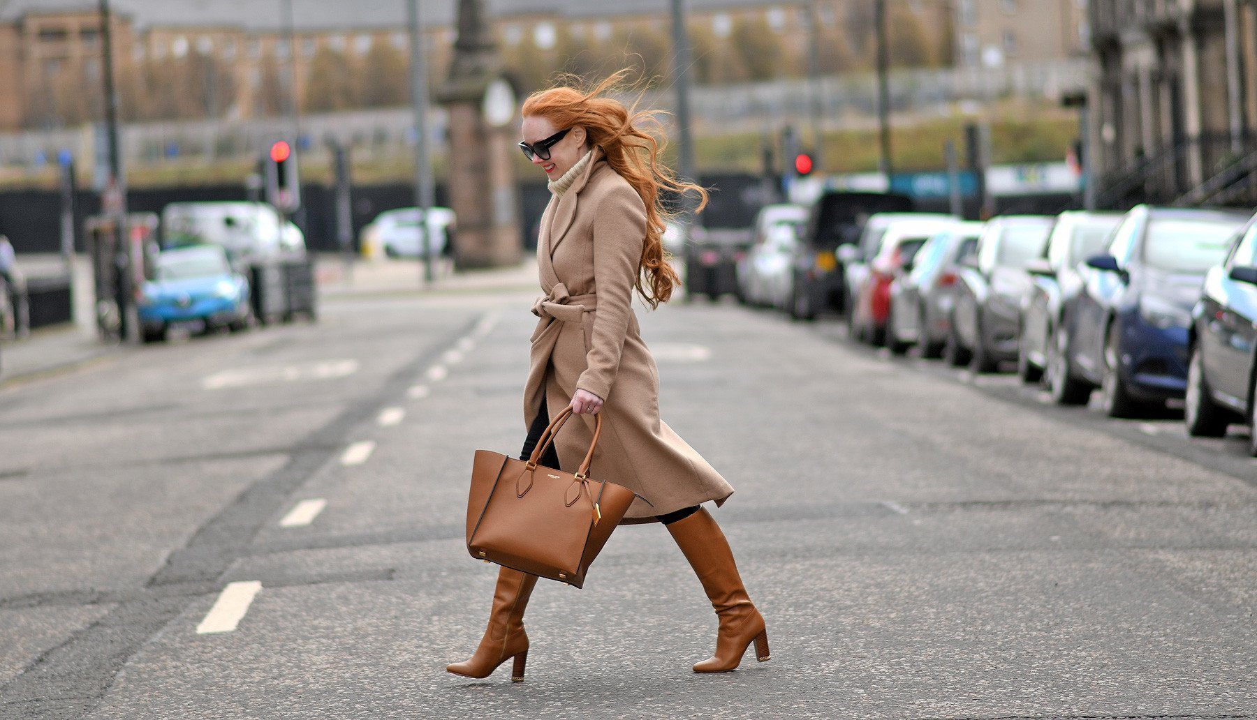 winter outfit photo featuring camel coat and tan knee boots