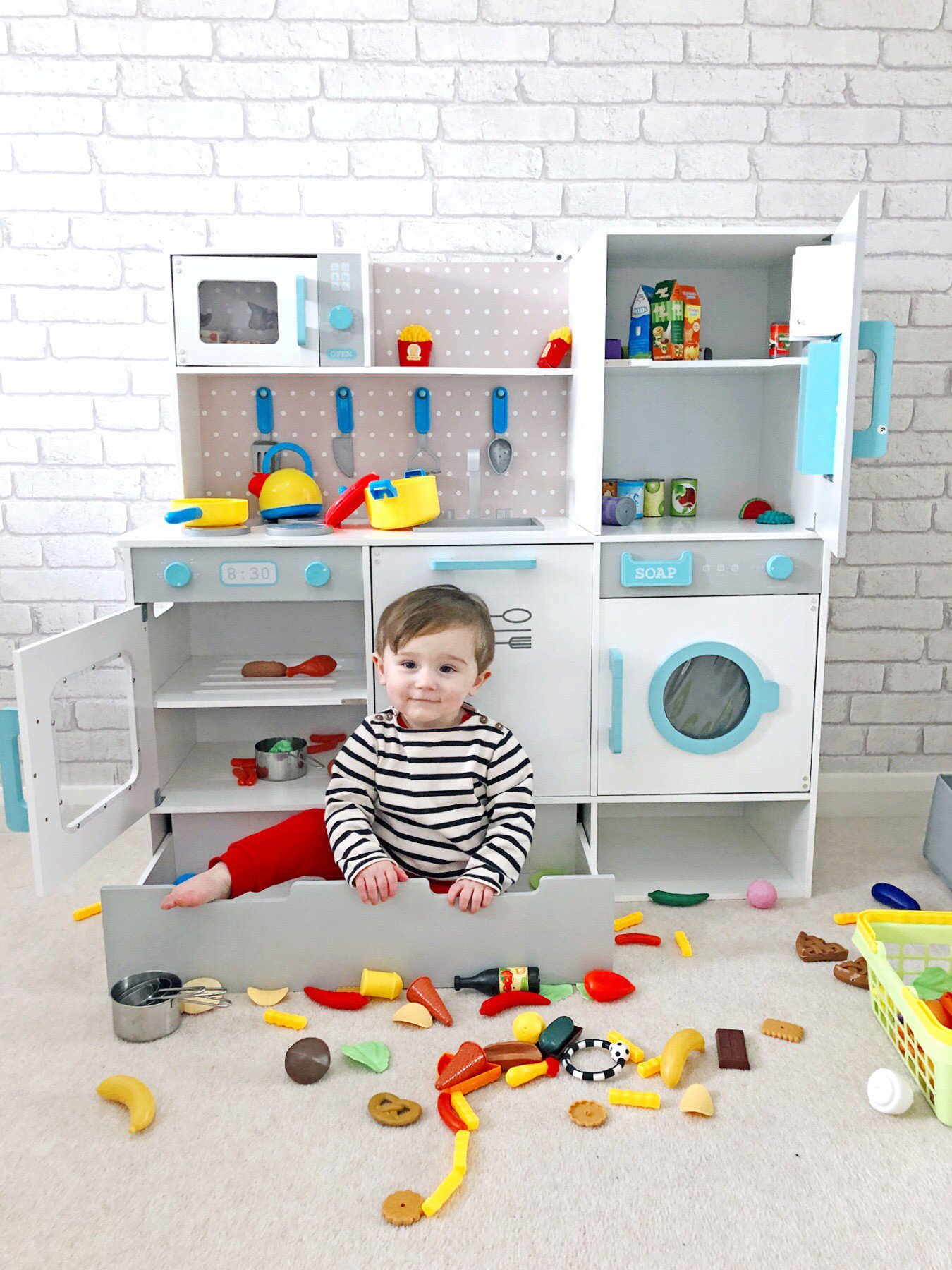 toddler in toy kitchen