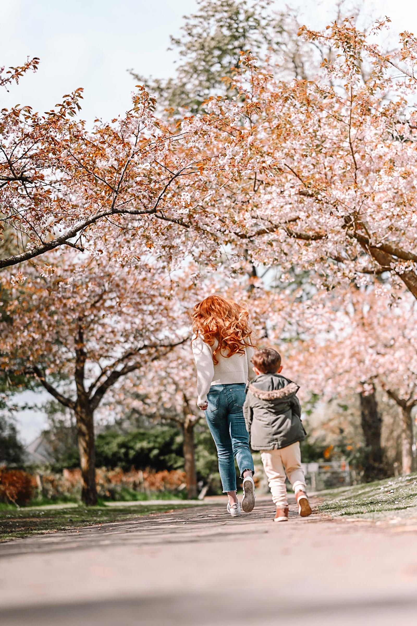 Amber and Max running through the cherry blossom trees in Edinburgh, spring 2021