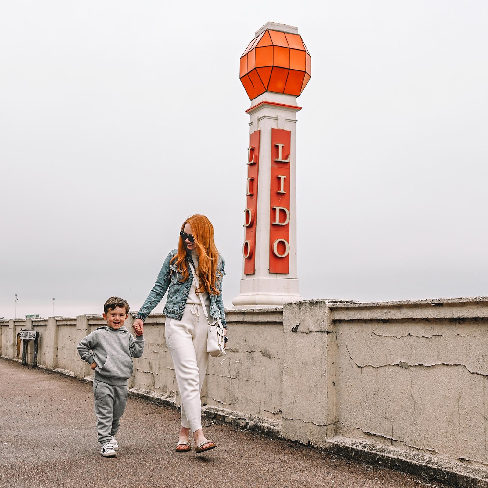 Amber and Max walking past the lido sign at Margate, Kent