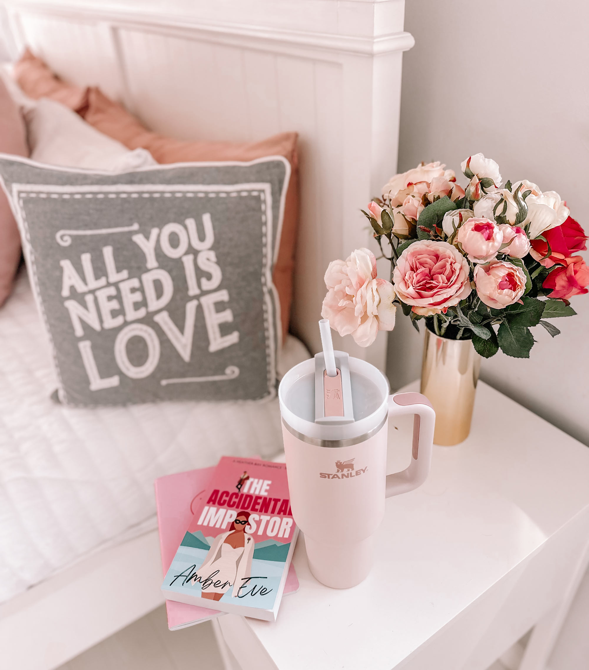 pink Stanley Quencher mug on bedside table