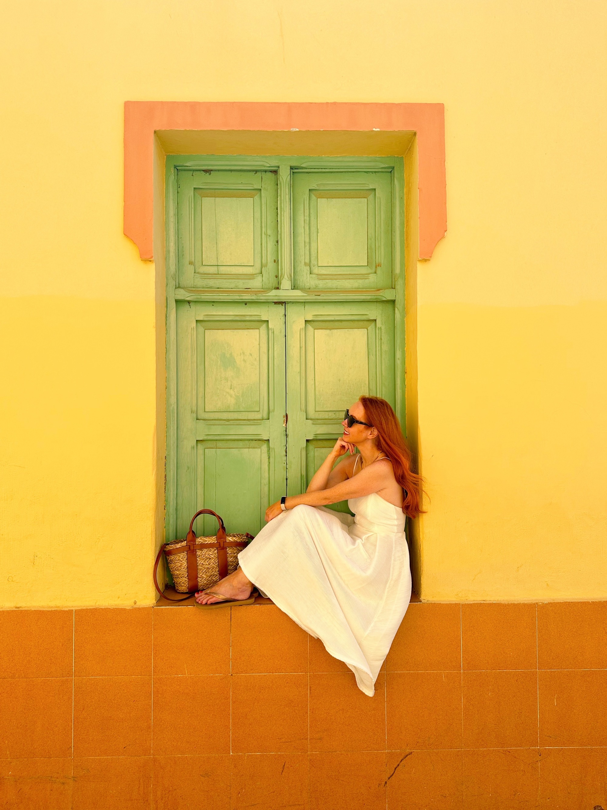 Amber sitting in a colourful green and yellow window in Gran Canaria