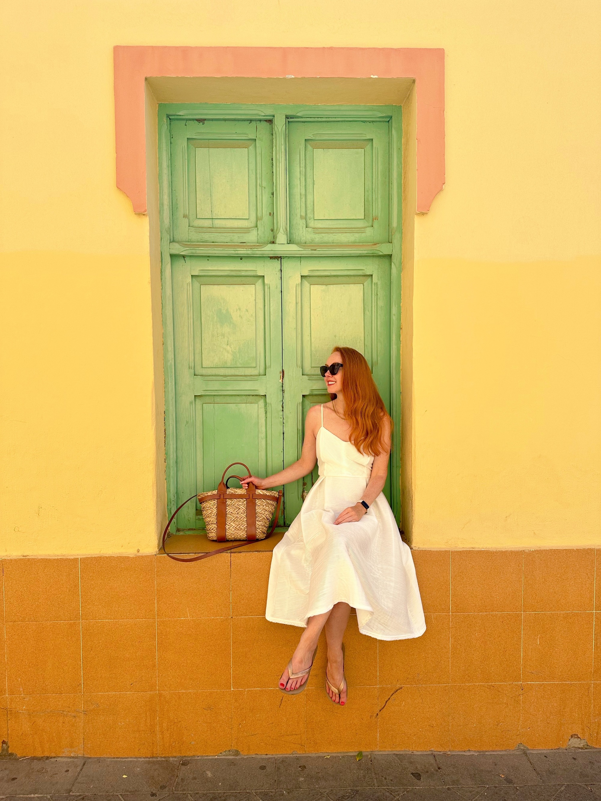 Amber sitting on a yellow wall in Gran Canaria